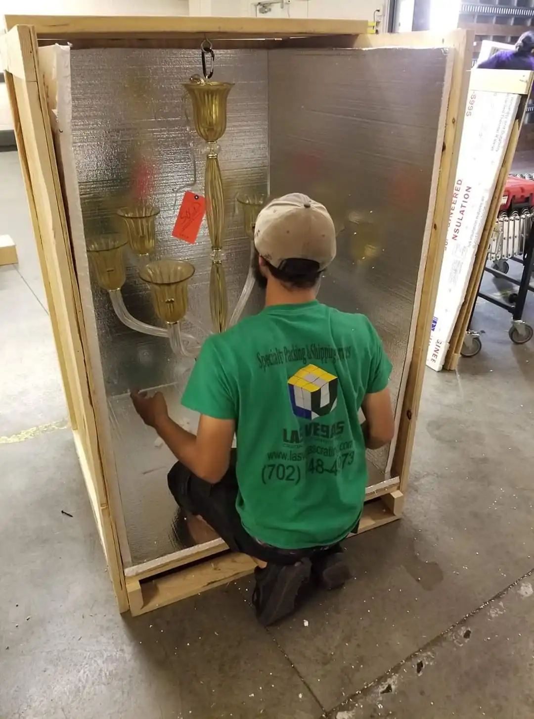 Staff member custom-crating a chandelier for shipment